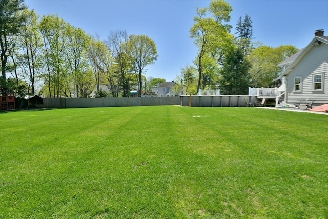 view of yard featuring a wooden deck and fence