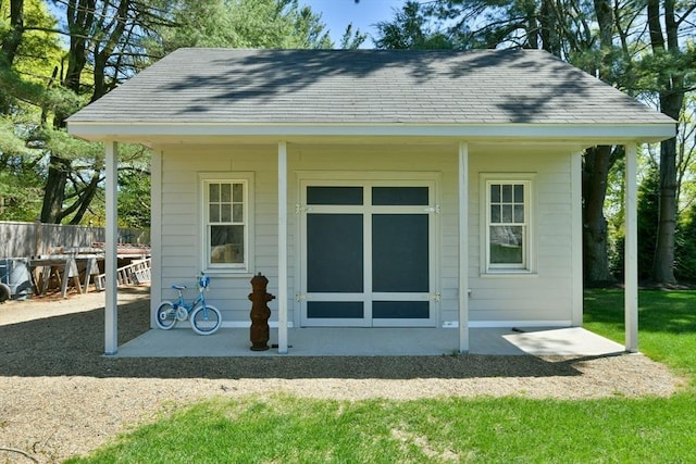 rear view of house with roof with shingles and fence