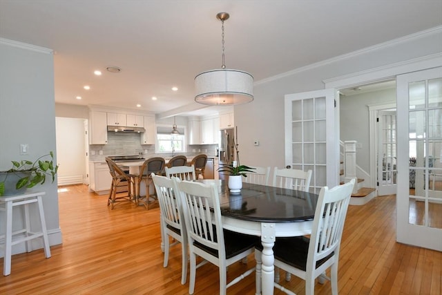 dining room with light wood-type flooring, french doors, ornamental molding, and recessed lighting