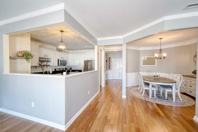 kitchen with light countertops, visible vents, an inviting chandelier, appliances with stainless steel finishes, and white cabinets