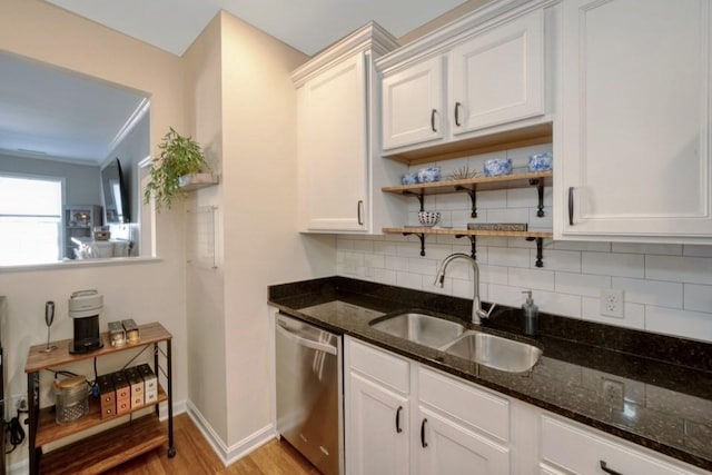 kitchen with dishwasher, a sink, and white cabinetry