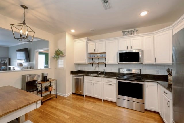 kitchen featuring stainless steel appliances, dark countertops, and white cabinets