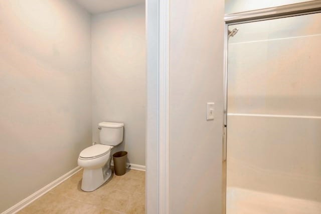 bathroom with toilet, tile patterned flooring, and baseboards