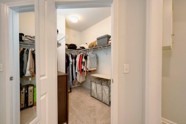 spacious closet featuring light colored carpet