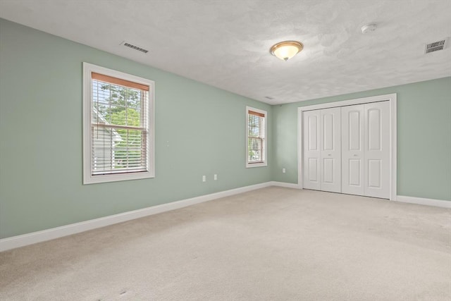 41 Winter Ln Unit 41, Tewksbury, MA 01876 - unfurnished bedroom featuring multiple windows, light colored carpet, and baseboards