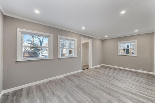 unfurnished room with light wood-type flooring, crown molding, and a healthy amount of sunlight