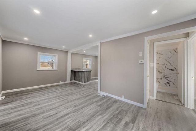 unfurnished room with light hardwood / wood-style flooring and crown molding