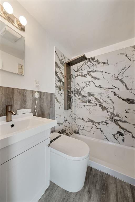 bathroom with vanity, tile walls, toilet, hardwood / wood-style flooring, and tiled shower