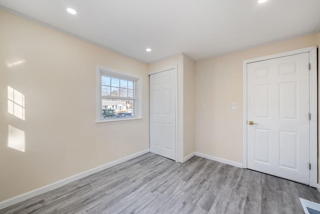 unfurnished bedroom with crown molding and light hardwood / wood-style floors