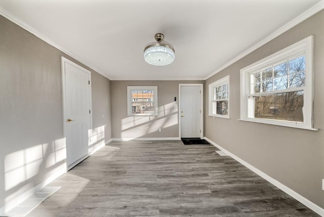 foyer entrance with crown molding and wood-type flooring