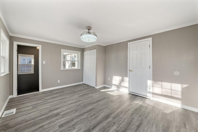 spare room with crown molding and wood-type flooring