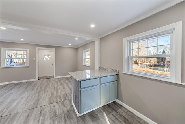 kitchen featuring light stone counters, light hardwood / wood-style floors, and a healthy amount of sunlight