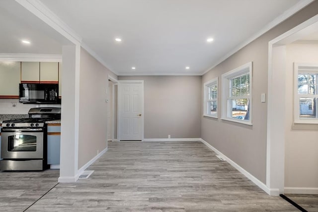 kitchen featuring light hardwood / wood-style floors, plenty of natural light, ornamental molding, and stainless steel range with gas stovetop