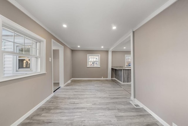 hallway with light hardwood / wood-style flooring and crown molding