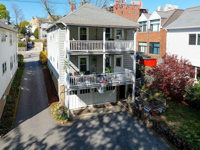view of front of home featuring a residential view, a balcony, and roof with shingles