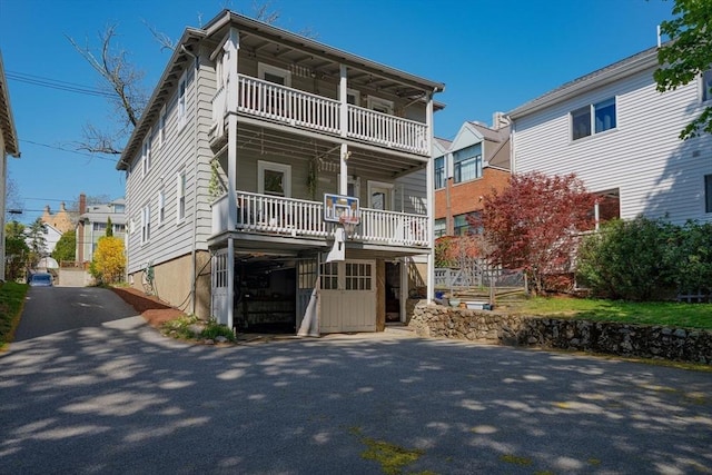 view of front of home with driveway and a balcony