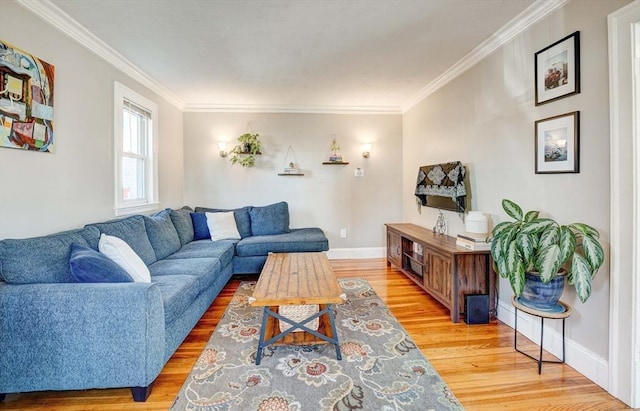 living room featuring light wood-style floors, ornamental molding, and baseboards
