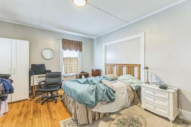 bedroom featuring light wood-style floors and crown molding