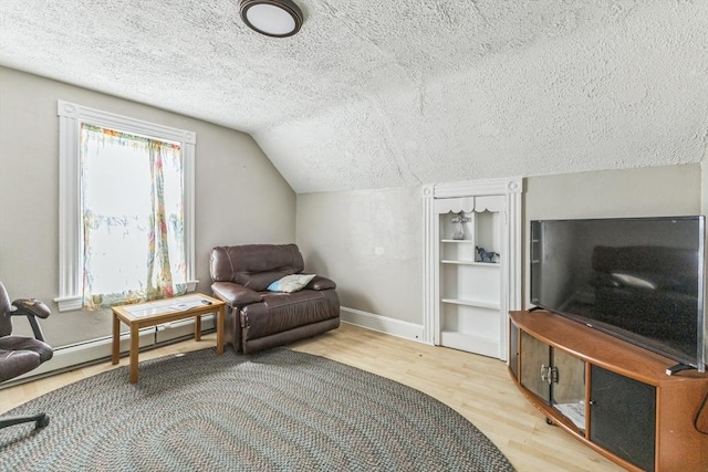 sitting room featuring wood finished floors, a textured ceiling, baseboards, and lofted ceiling
