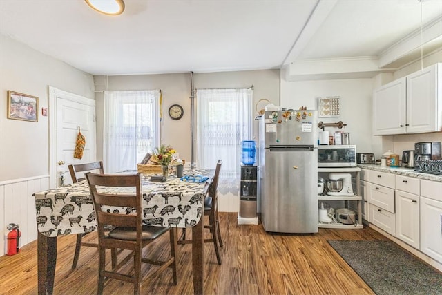 dining room with wood finished floors and wainscoting