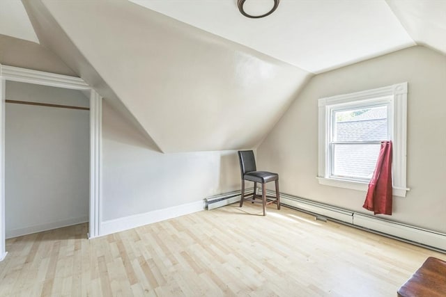 additional living space featuring vaulted ceiling, wood finished floors, a baseboard radiator, and baseboards