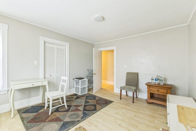 living area featuring wood finished floors, crown molding, and baseboards