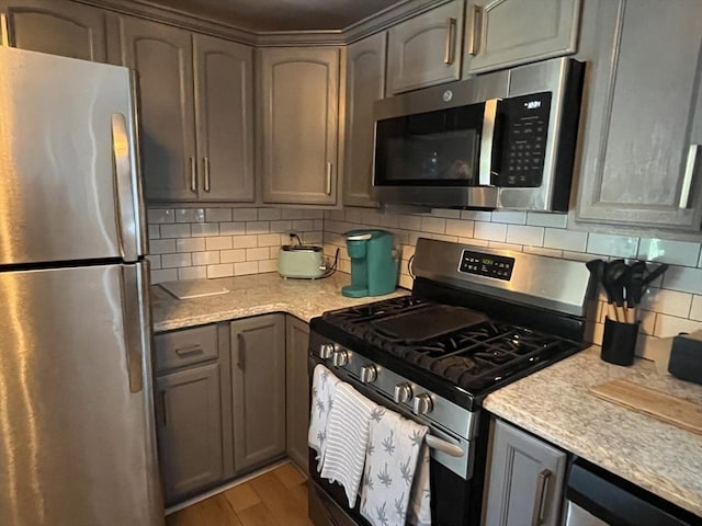 16 Douglas Ave, Beverly, MA 01915 - kitchen with appliances with stainless steel finishes, decorative backsplash, light countertops, light wood-style flooring, and gray cabinetry