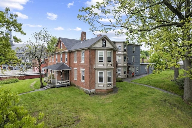 51 Prospect St, Webster, MA 01570 - back of property featuring a chimney, a lawn, and brick siding