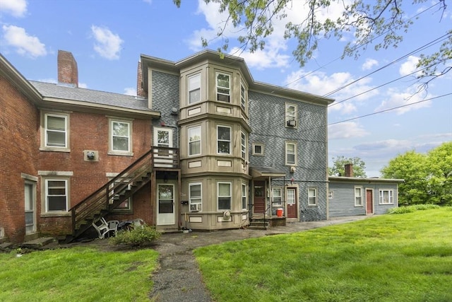 51 Prospect St, Webster, MA 01570 - back of property with a yard, stairs, brick siding, and a chimney