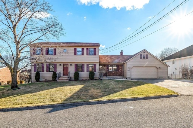 colonial home featuring a front lawn and a garage