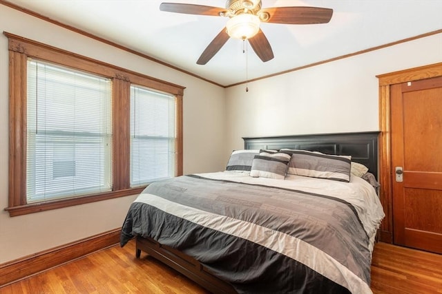 bedroom featuring light wood-type flooring, ceiling fan, and ornamental molding