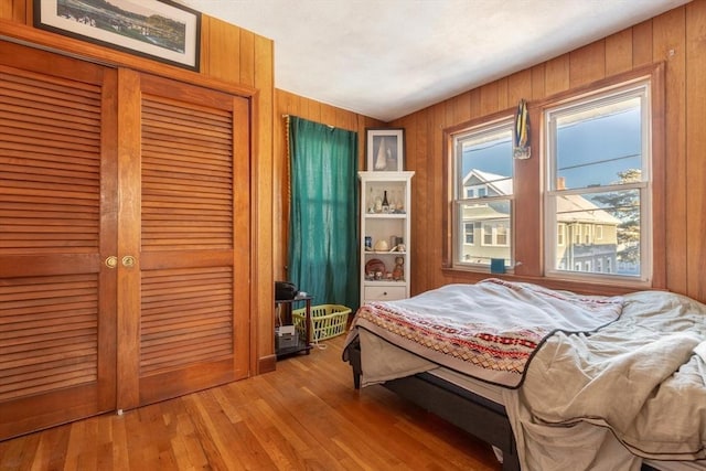 bedroom featuring hardwood / wood-style floors and wood walls