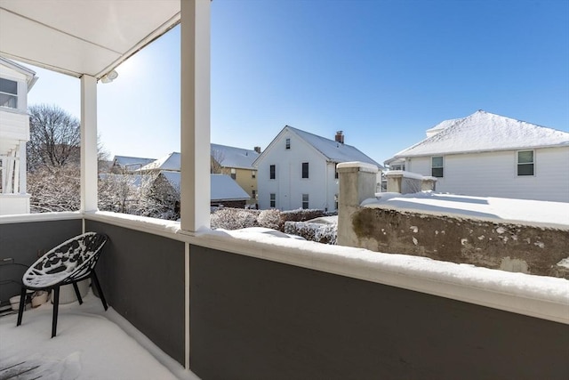 view of snow covered back of property