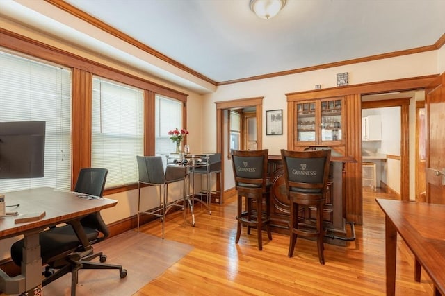 office area featuring light wood-type flooring and crown molding