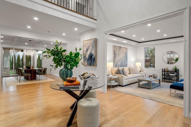 living room featuring beamed ceiling, coffered ceiling, and light hardwood / wood-style flooring