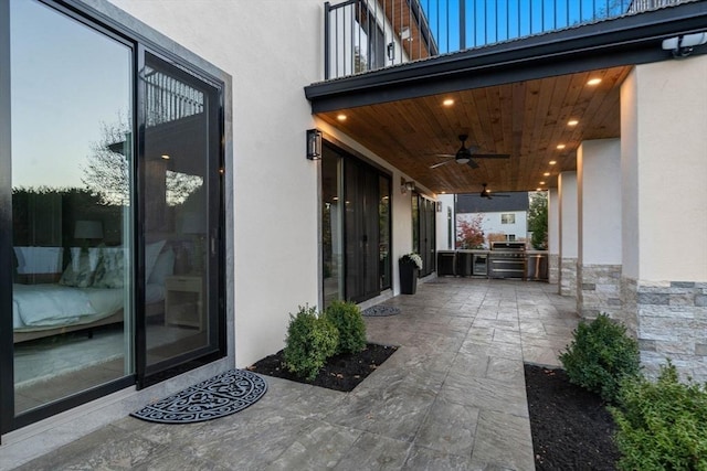 patio terrace at dusk featuring area for grilling and ceiling fan