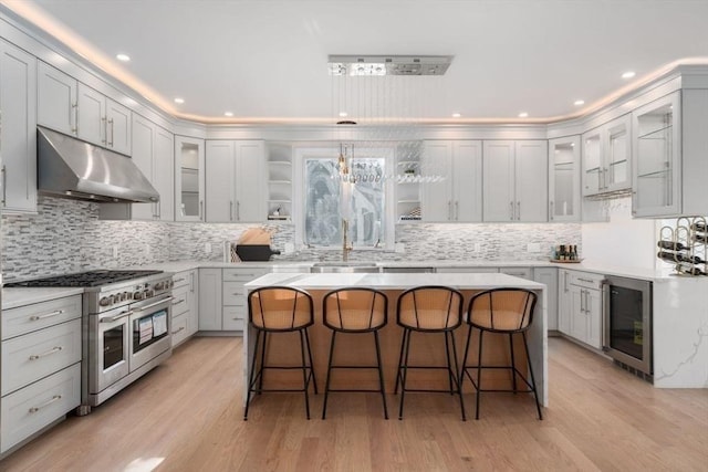 kitchen featuring wine cooler, double oven range, a kitchen bar, and a kitchen island