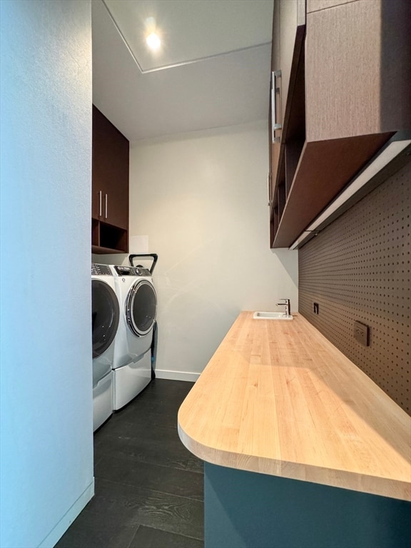 laundry room featuring dark wood-type flooring, sink, cabinets, and washer and dryer