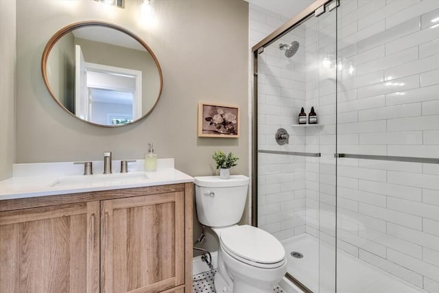 bathroom with toilet, a stall shower, and vanity