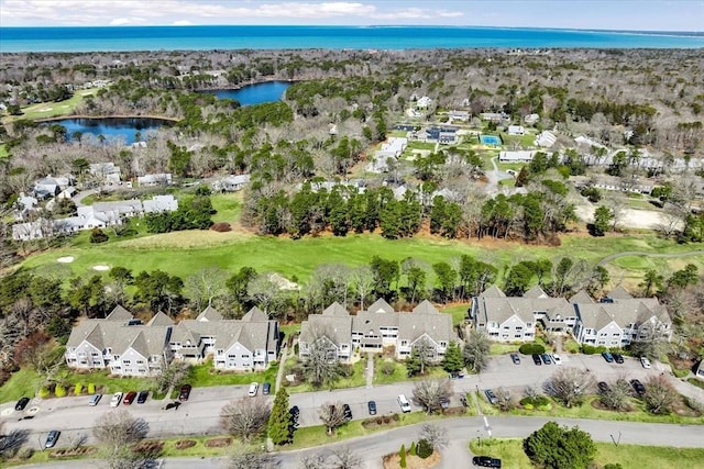 aerial view of property and surrounding area with nearby suburban area, a large body of water, and a local golf course