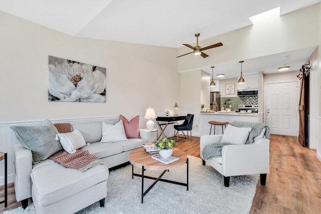 living room with ceiling fan and light wood-type flooring