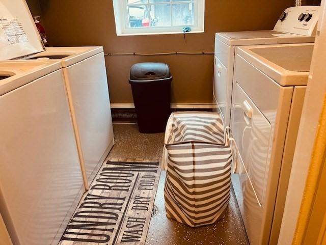 clothes washing area with washer and clothes dryer, laundry area, and baseboards
