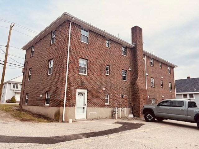 view of side of home with brick siding and a chimney