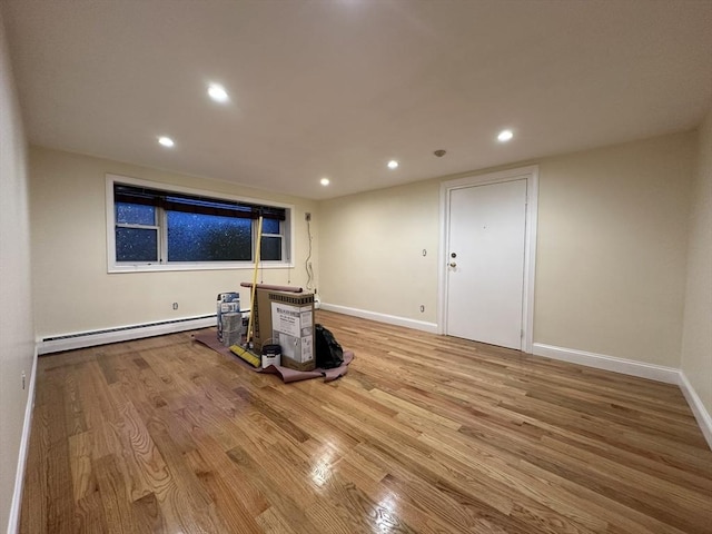 spare room featuring recessed lighting, baseboard heating, baseboards, and wood finished floors