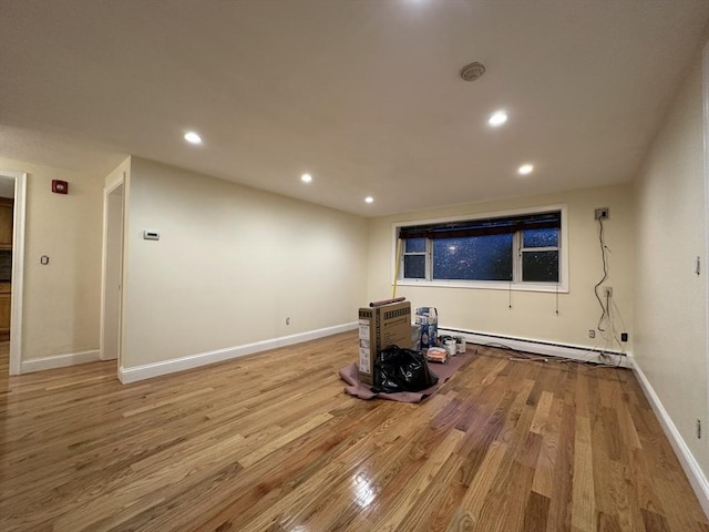 interior space with a baseboard radiator, wood finished floors, baseboards, and recessed lighting