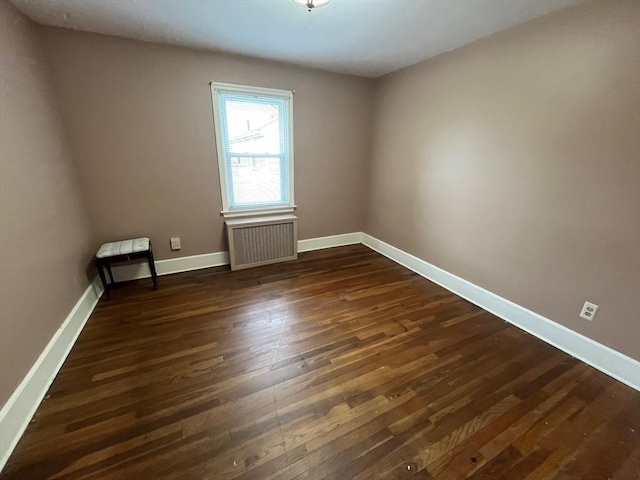 189 Bush St, Fall River, MA 02724 - empty room featuring radiator heating unit, dark wood-style flooring, and baseboards
