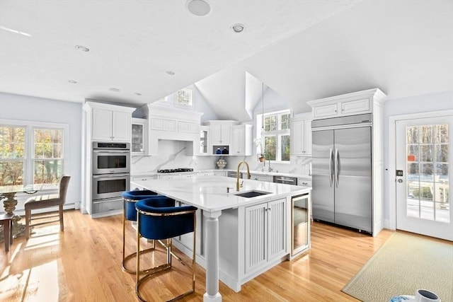 kitchen featuring white cabinetry, appliances with stainless steel finishes, sink, and a center island with sink