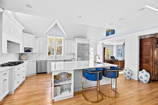 kitchen with appliances with stainless steel finishes, a center island, sink, and white cabinets