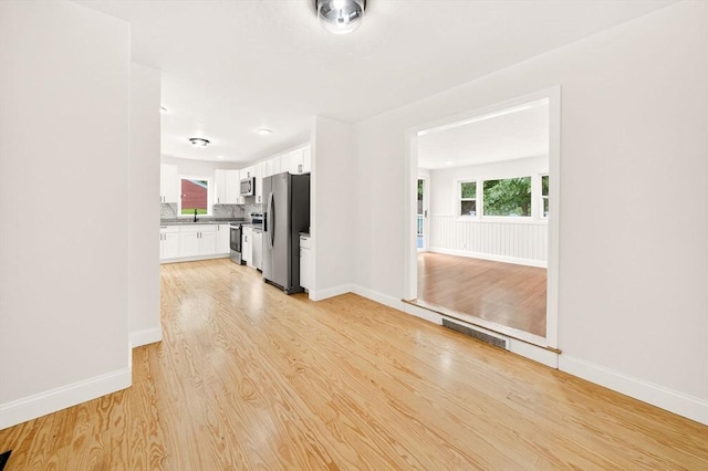 70 Hancock St, Whitman, MA 02382 - unfurnished living room with light wood-style floors and baseboards