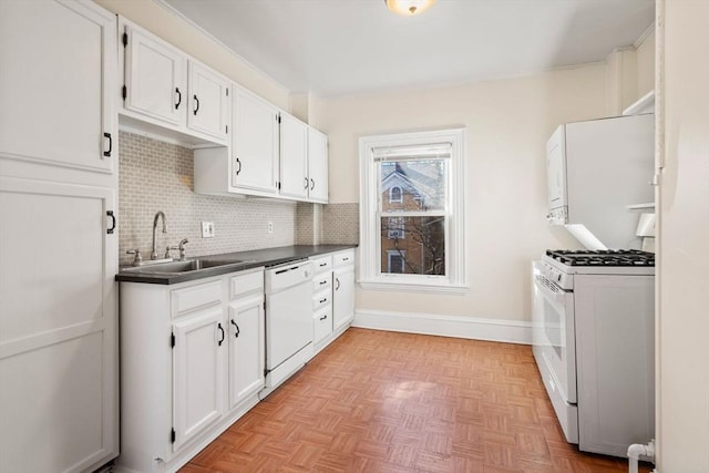 kitchen with dark countertops, decorative backsplash, white cabinets, white appliances, and a sink